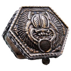 Silver hexagonal pill box with reliefs on the hinged lid