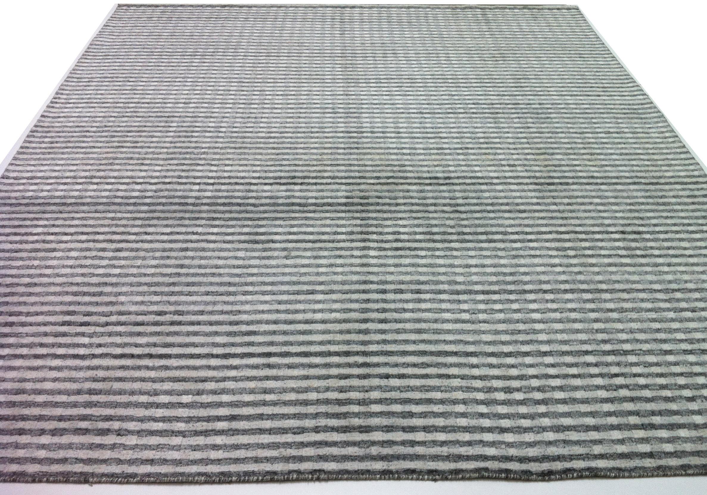 High and low pile combine to create a woven look and feel in this sleek wool area rug.  Best suited for low to medium traffic areas.  Grey/silver/charcoal/slate/black tones. Viscose/Cotton.  Hand knotted in India. 

Available in multiple sizes 