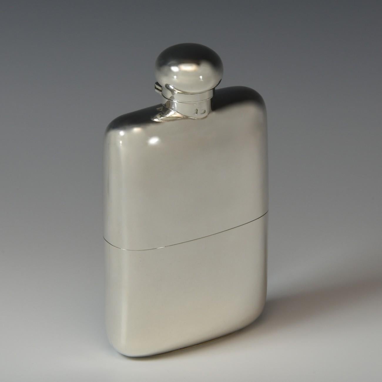 An excellent solid Sterling silver hip flask, hallmarked London 1907. The silver body of the flask and it is topped with a cork lined stopper that is on a hinged bayonet closer. The silver section covering the bottom of the flask slides off to form