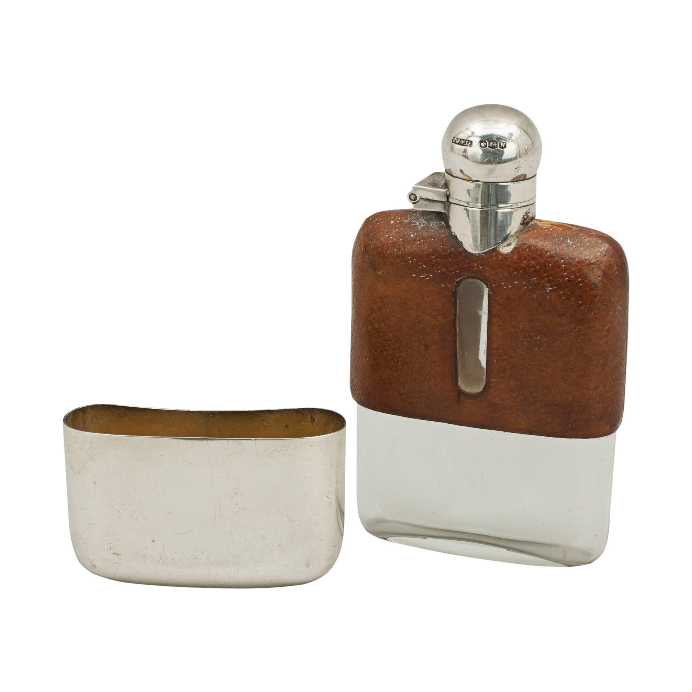 Leather and silver hip flask.
A very nice silver spirit hip flask with the top half covered in leather with level viewing windows cut into both sides. The flask with hinged lid with screw bayonet fitting, bottom with a removable silver drinking