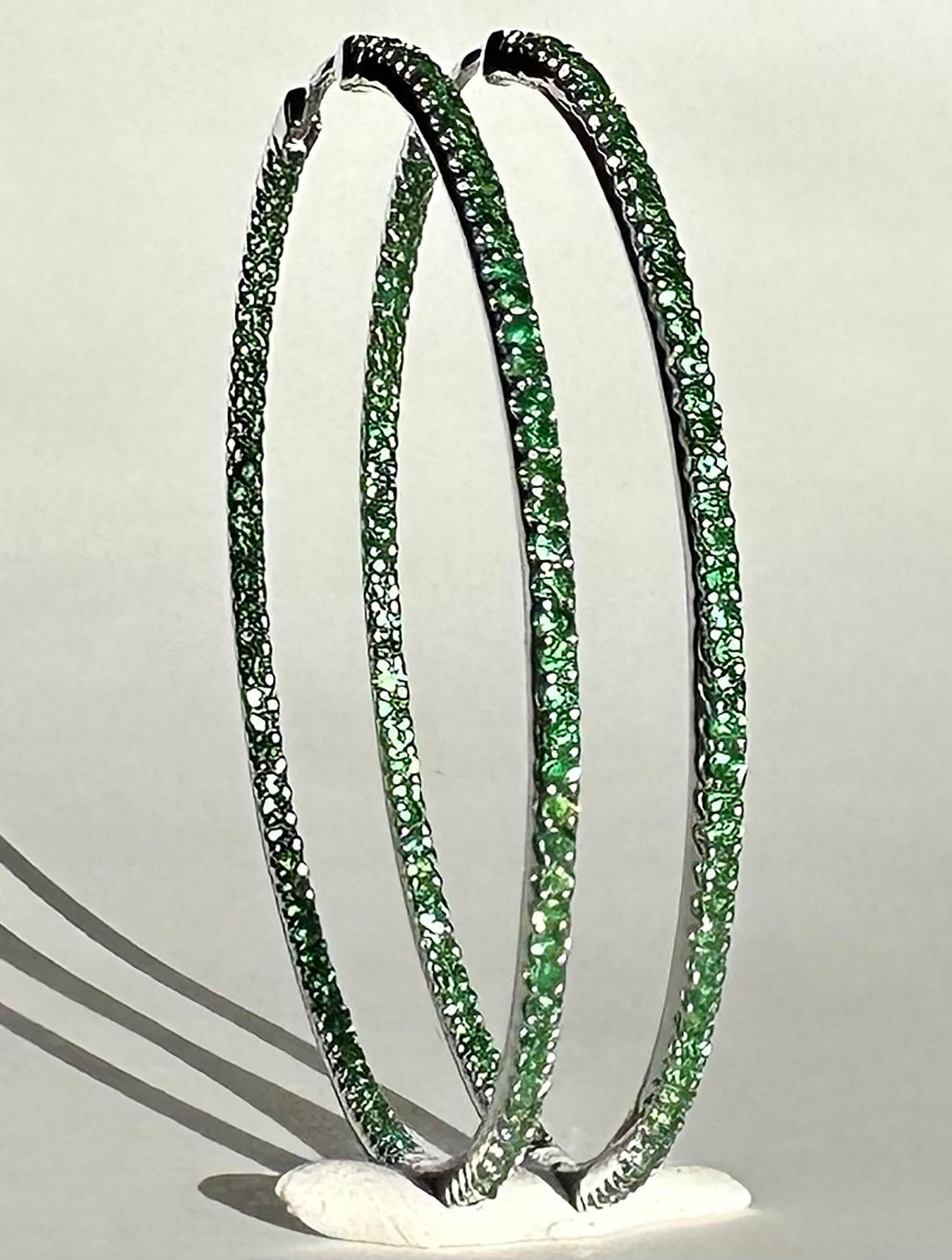 A pair of luxurious Silver Hoop Earrings set with 190 1.4MM Tsavorite Garnets. All these scintillating garnets face forward to catch light and attention. Be the center of attention wherever you wear these as they are eye and attention catching