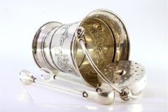 Silver ice bucket and tongs with reliefs surrounding monogram cards