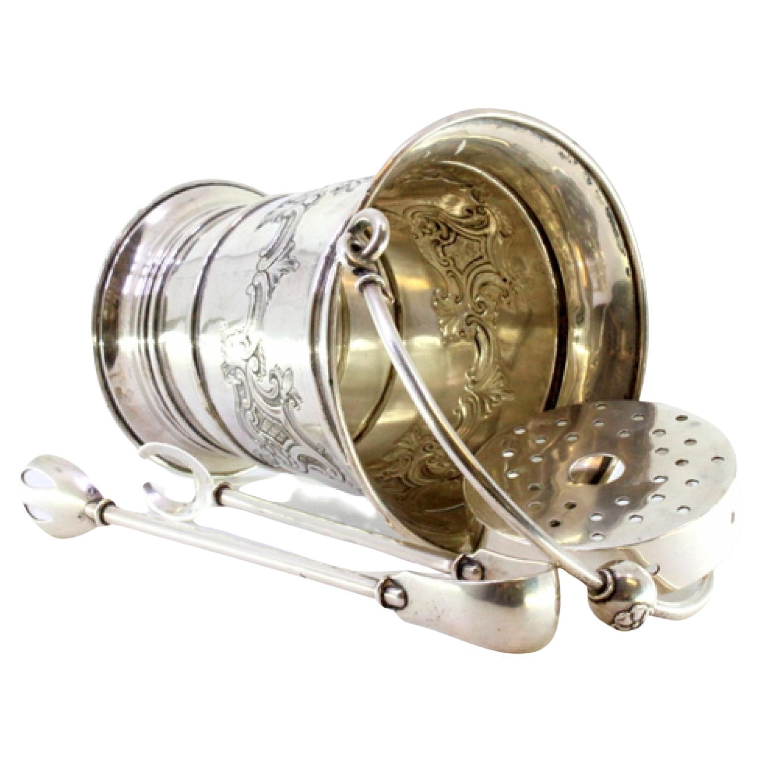 Silver ice bucket and tongs with reliefs surrounding monogram cards
