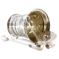 Silver ice bucket and tongs with reliefs surrounding monogram cards