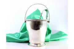 Silver ice bucket with embossed rim, tongs and movable handle