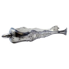 Silver ice tongs in the shape of claws with engraved plant motifs