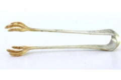 Silver ice tongs in the shape of gold bird claws