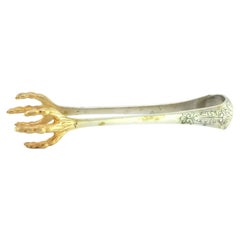 Silver ice tongs in the shape of gold bird claws