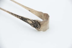 Silver ice tongs with reliefs and friezes