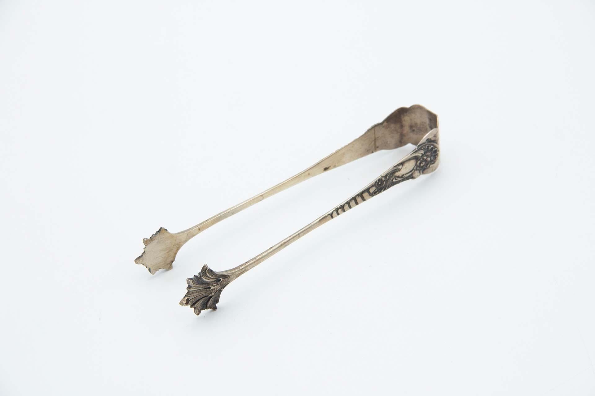 Silver ice tongs with reliefs and friezes