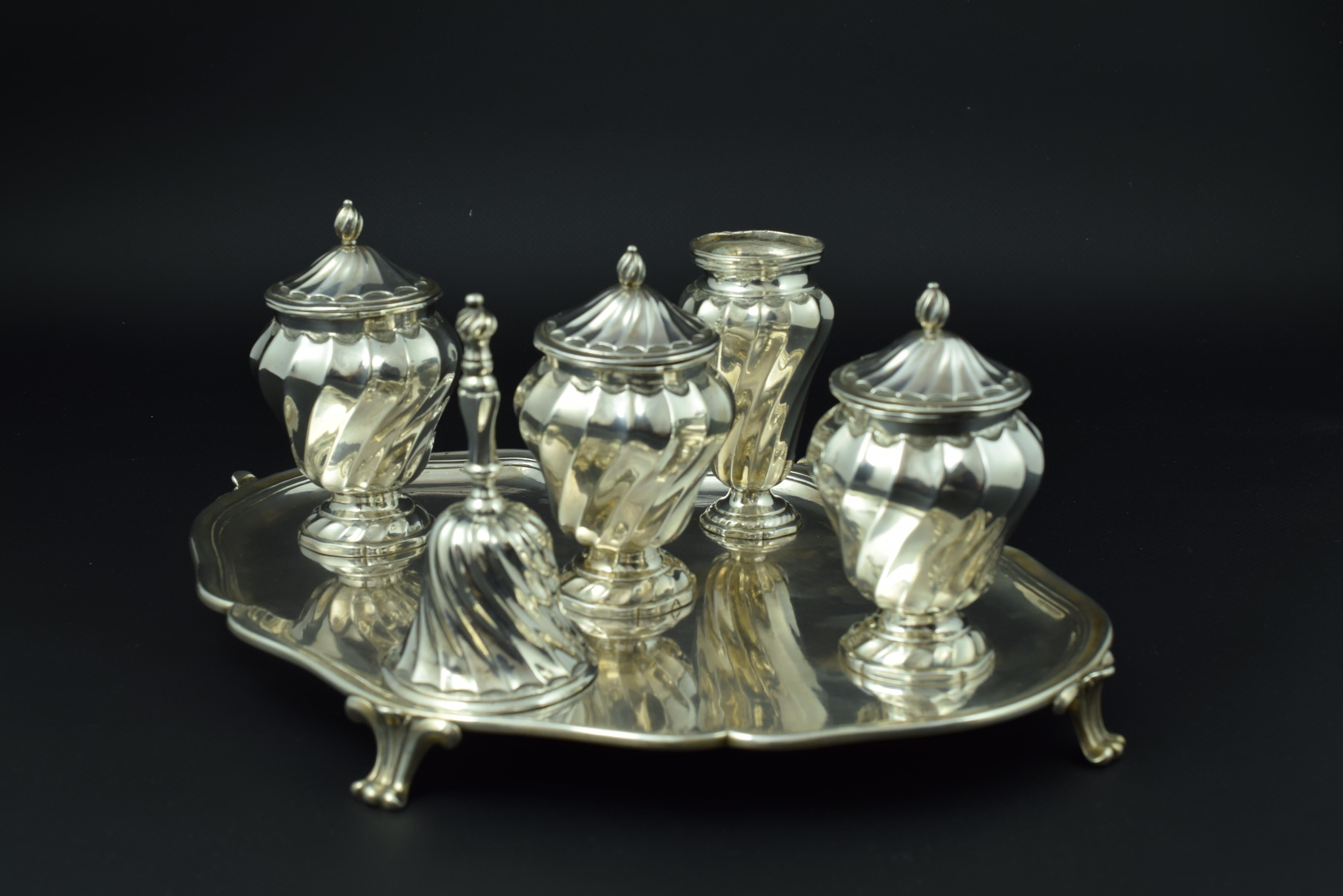 With hallmarks and property marks (AL).
A tray of curved profiles is supported on four legs in the shape of plant elements. Fixed to it are four elements. These, and the bell, present a magnificent decoration based on flat gallons (shell shapes)