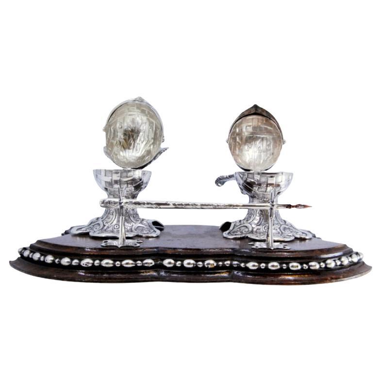 Silver inkwell on rosewood with helmet-shaped tanks 
pen holder