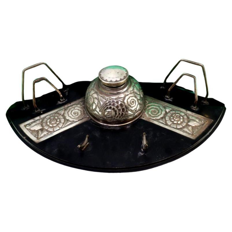 Silver inkwell w/ letter holders 
pen w/ inkwell, resting on a wooden base