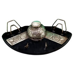 Silver inkwell w/ letter holders 
pen w/ inkwell, resting on a wooden base