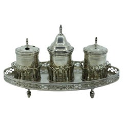 Silver inkwell w/ rack, two reservoirs, pen holder, bell 
standing on four feet