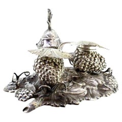 Silver inkwell with grape motifs, bell, sandpit 
hinged lids