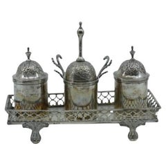 Silver inkwell with rack, bell, two tanks, pen holder and set on four claw feet