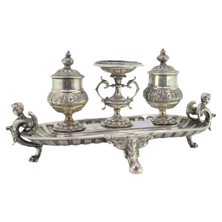 Silver inkwell with two tanks, base with mask applications and claw-shaped feet