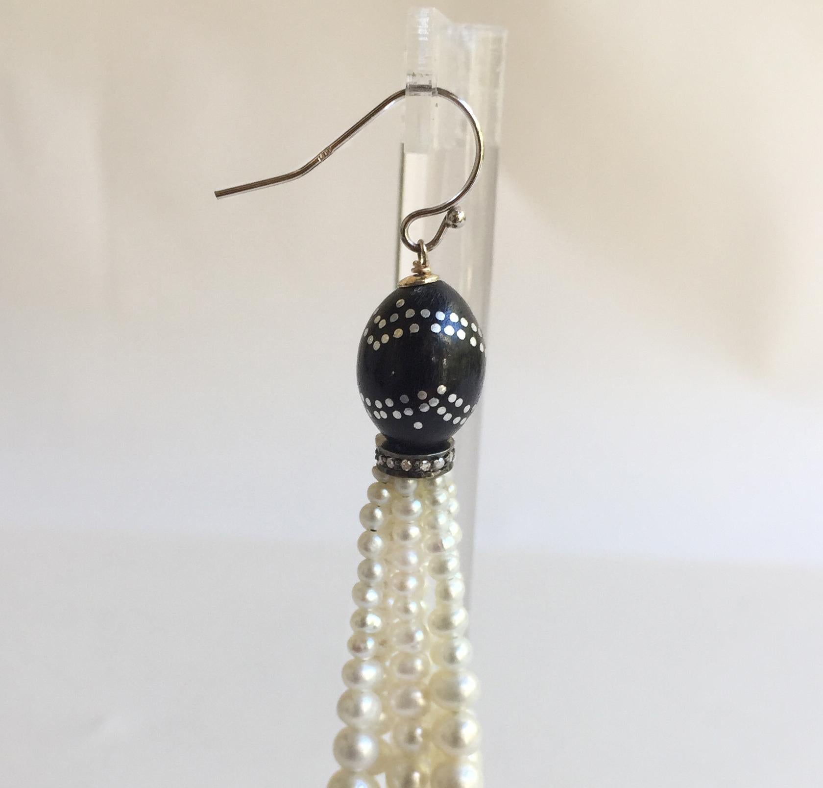 These striking black and silver inlay wooden and white pearl tassel earrings have a diamond roundel and 14k white gold hook to accent the contrasting black and white of the other beads. At 2.9 inches they are elegant and frame the face well, with