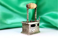 Silver iron w/ applications & reliefs, wooden handle & three-legged cut-out rest