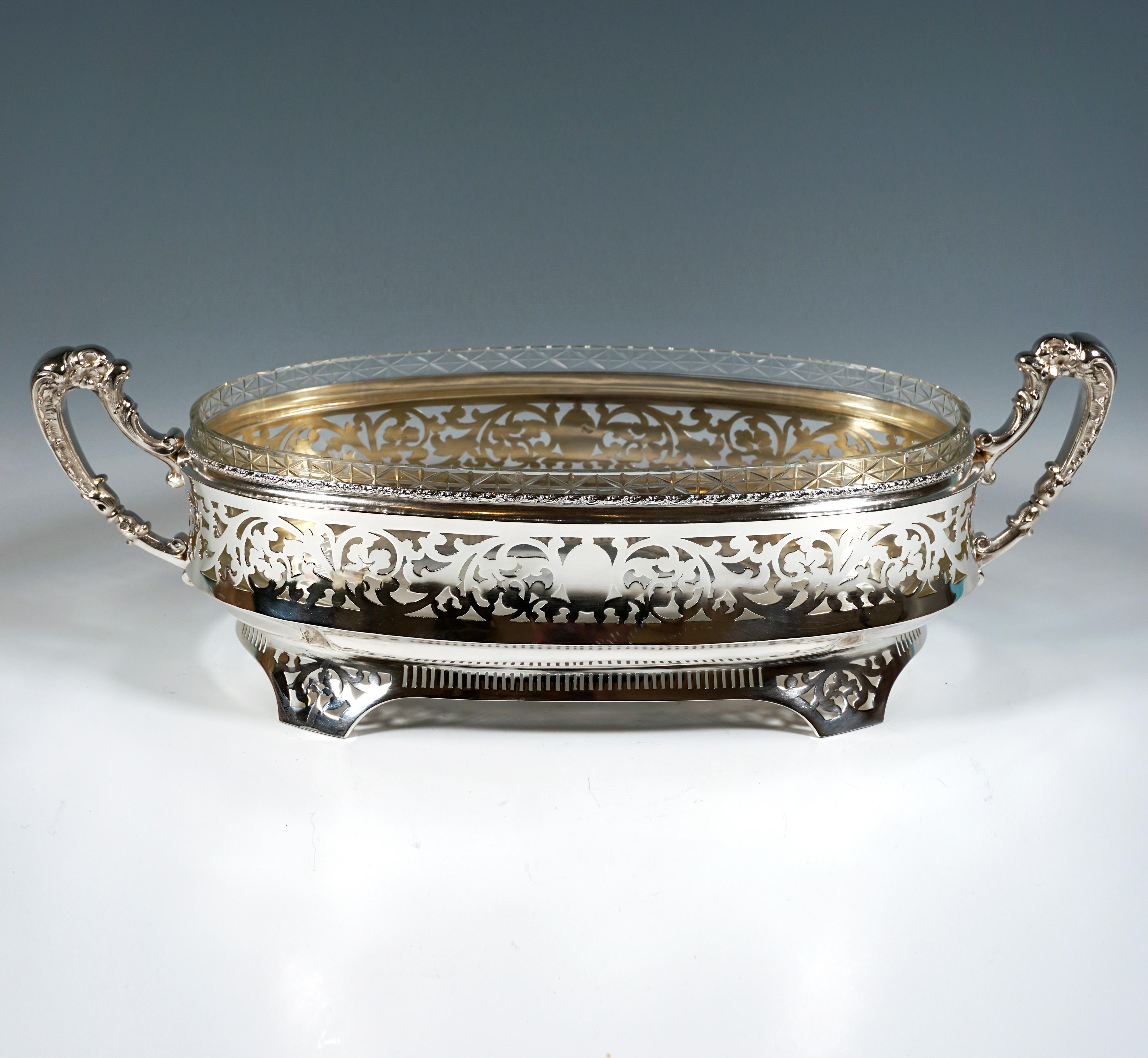 Elegant silver jardinière with an elliptical ground plan, the vertical wall slightly flared at the bottom and decorated with large-scale floral openwork, below a constriction and the formation of a foot section with four projecting feet with floral,