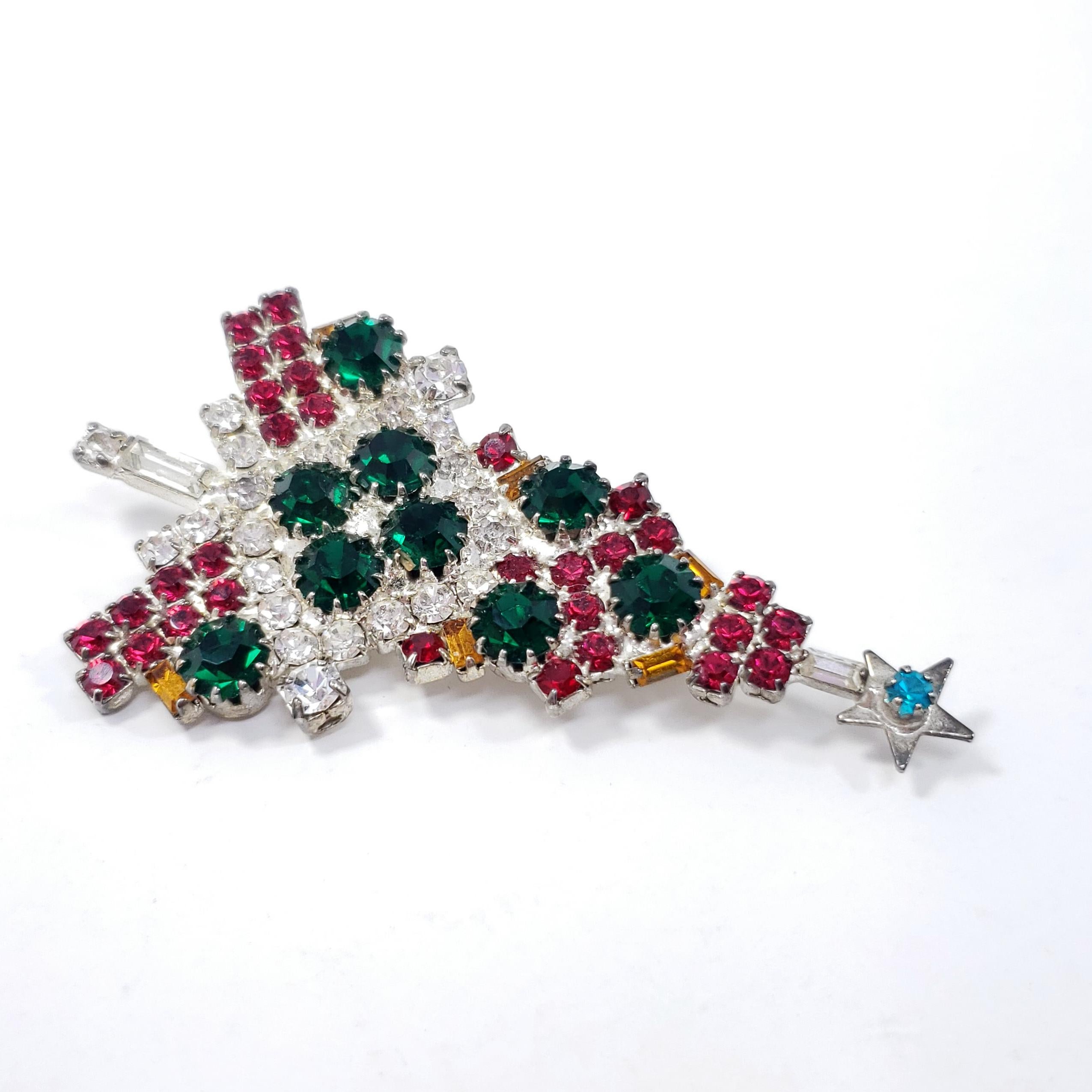 A dazzling Christmas tree, decorated with festive red, green, and clear crystals. A stylish holiday accessory!

Silver-tone. Prong-set crystals.