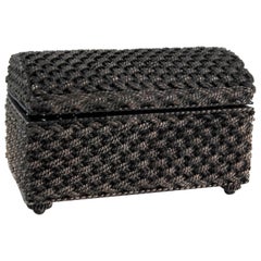 Joyero de plata con forma entrelazada, apoyado sobre cuatro patas y tapa abatible