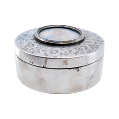 Silver jewelry box with engraved plant motifs surrounding an ancient lady