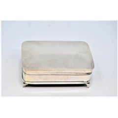 Silver jewelry box with engravings and standing on four cut-out feet