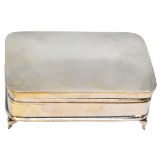 Silver jewelry box with engravings and standing on four cut-out feet