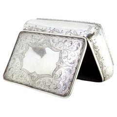 Silver jewelry box with plant engravings and central monogram plaque