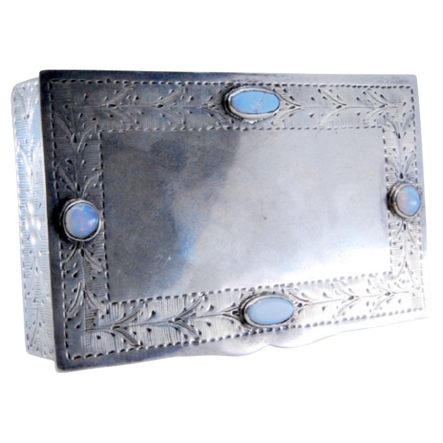 Silver jewelry box with plant engravings and colored stones on lid