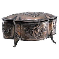 Silver jewelry box with plant-relief appliqués, four feet and hinged lid