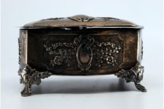 Silberne Schmuckschatulle mit Bändern und Monogramm, auf vier Füßen stehend