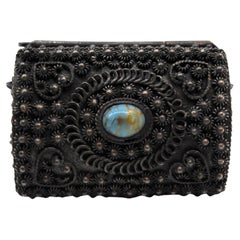 Silver jewelry box with rosette lining and cabochon on hinged lid