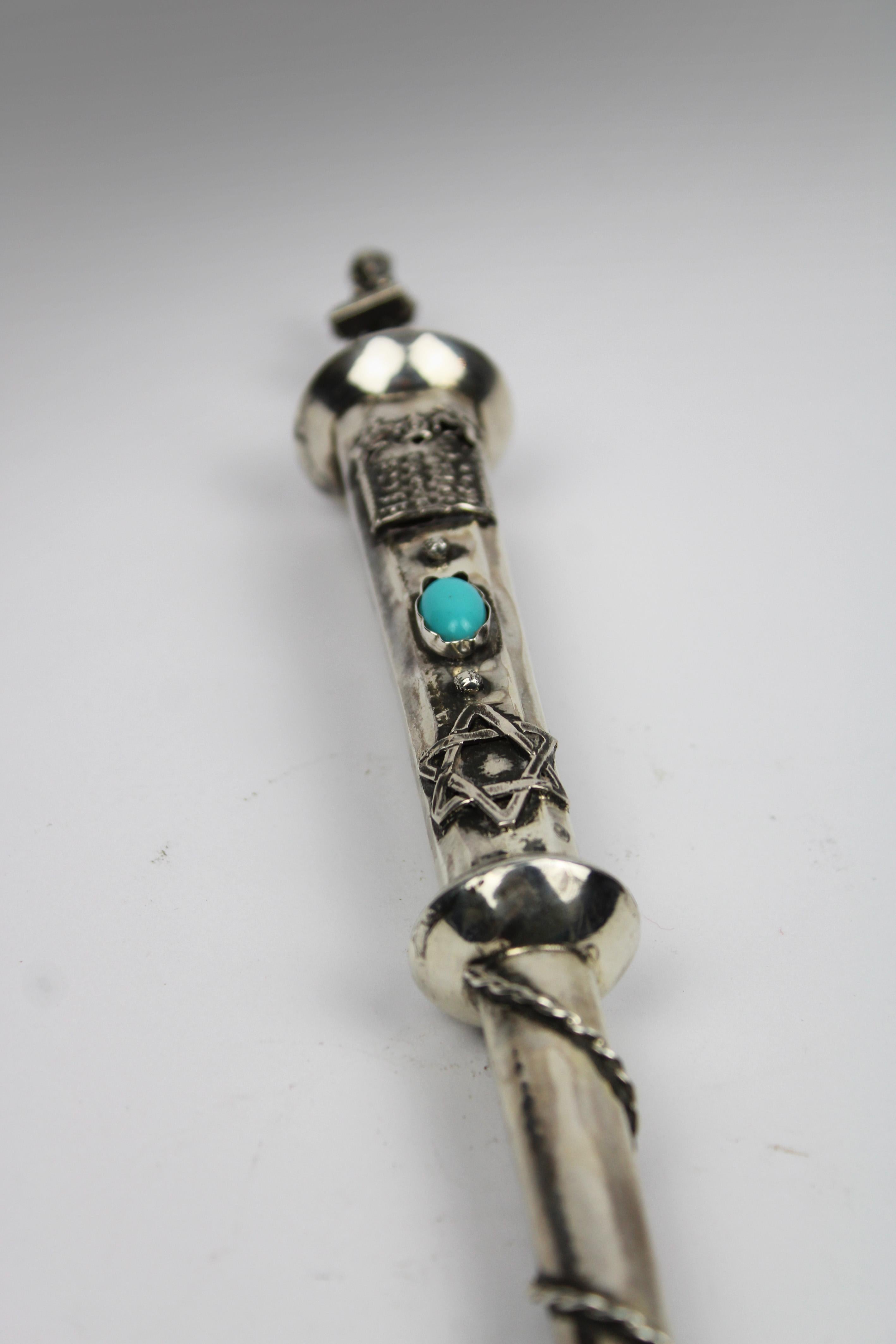 Presenting an exceptional 19th-century silver Jewish Torah pointer (Yad) from St. Petersburg, Russia, dated 1844. This exquisite religious item is adorned with a cabochon turquoise stone and features a finely crafted musician at the pommel. The