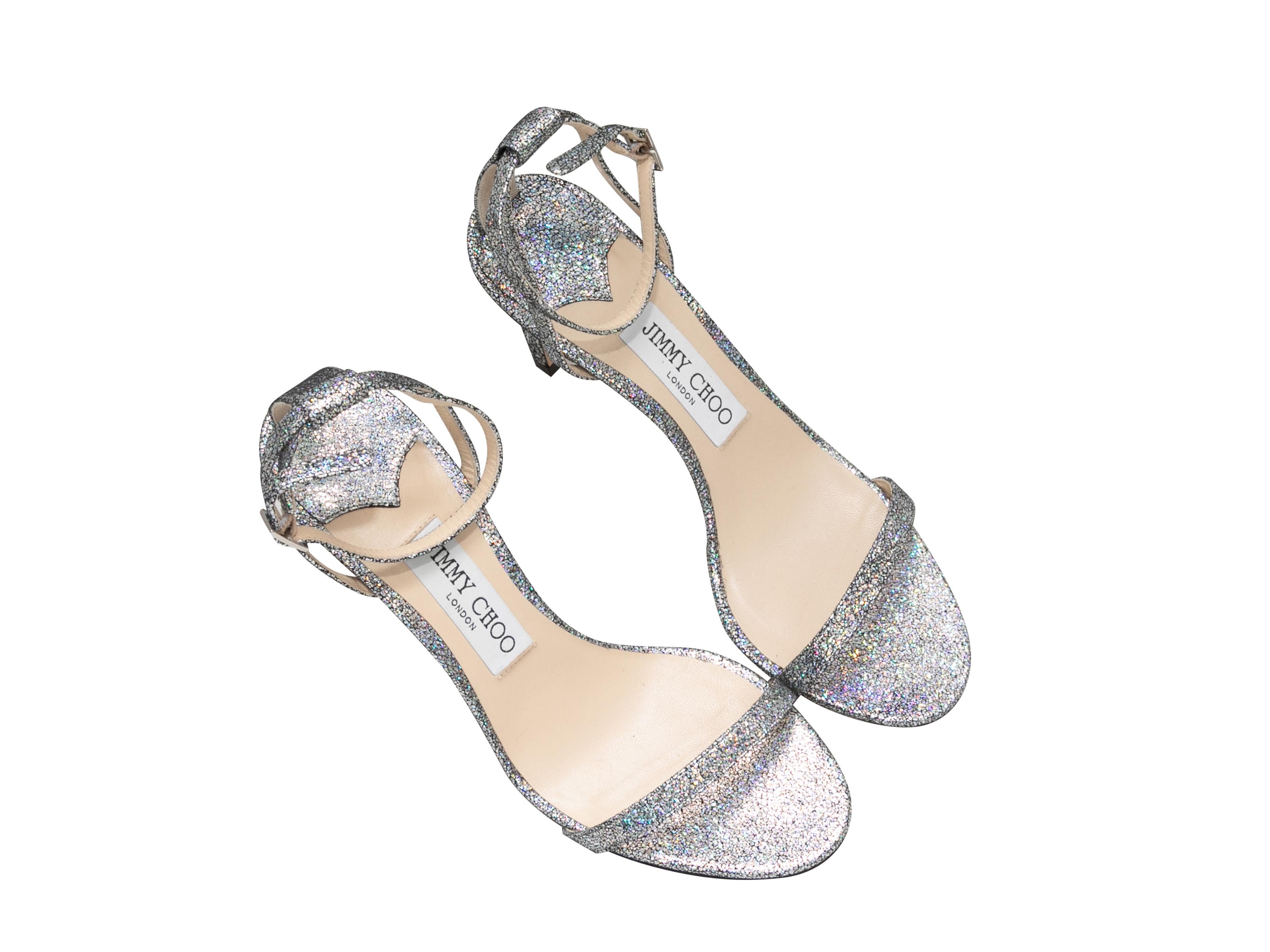 Silver glitter heeled sandals by Jimmy Choo. Buckle closures at ankle straps. 3