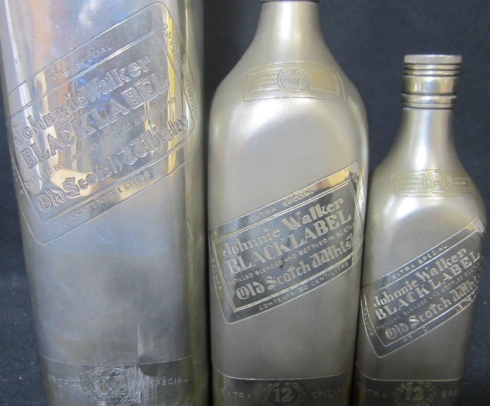 Set three silver Johnnie Walker black label bottles, largest 751grams, (8 x 29.5cm high) marked Sterling silver on base, middle size 438 grams (6.7 x 22cm high) marked silver on base, smallest 251 grams (5 x 18cm high) marked silver on