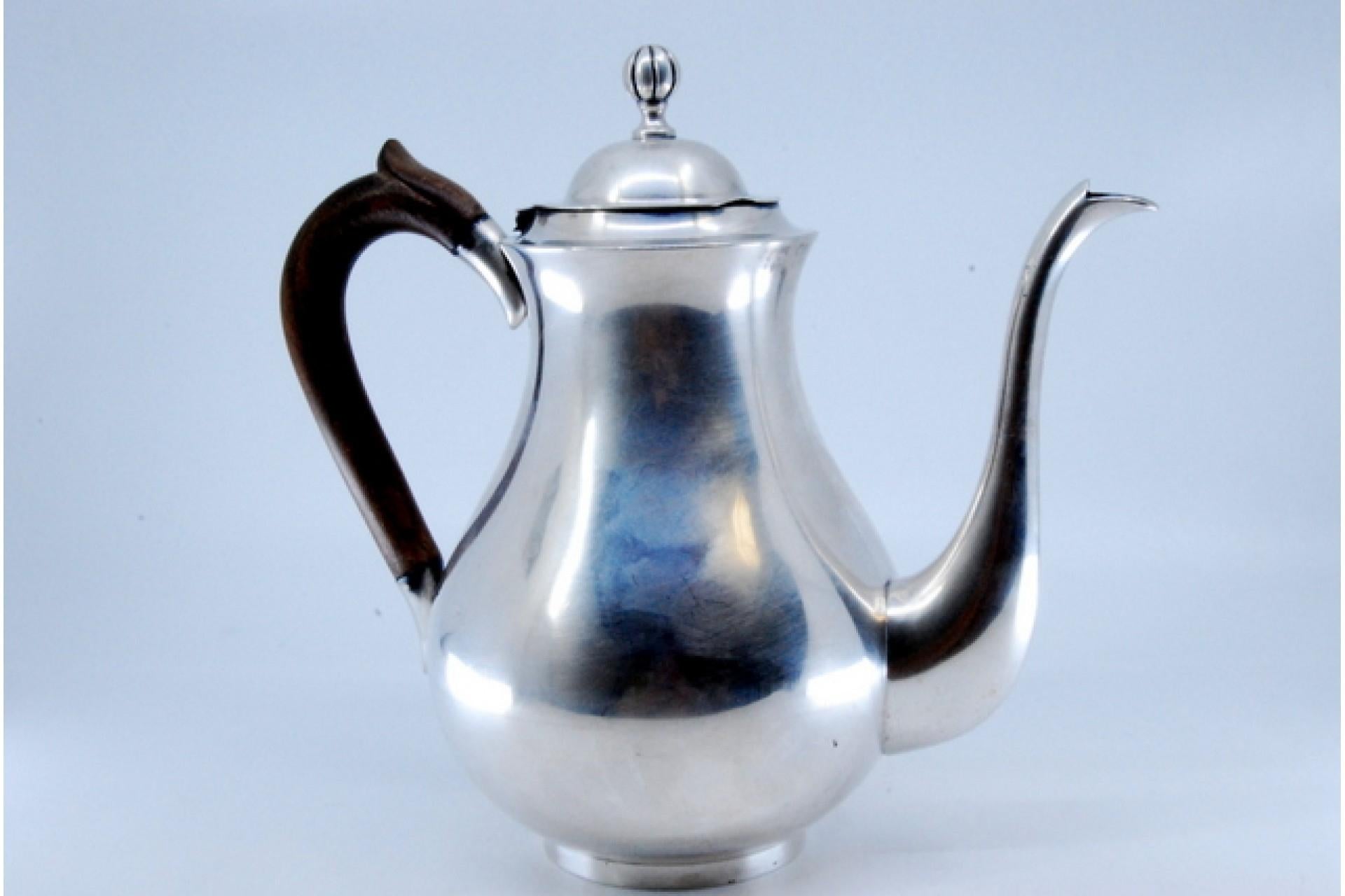 Description : Bouilloire en argent à corps lisse, couvercle surmonté d'un pommeau et poignée en bois de châtaignier. Métal : Argent. Origine : Portugais. Poinçon : aigle debout. Poids : 627,33 grammes. Dimensions : 21 x 6,8 cm : 21x6.8cm. Contenu :