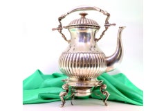 Silver kettle with embossing, trivet and heater on three tall feet
