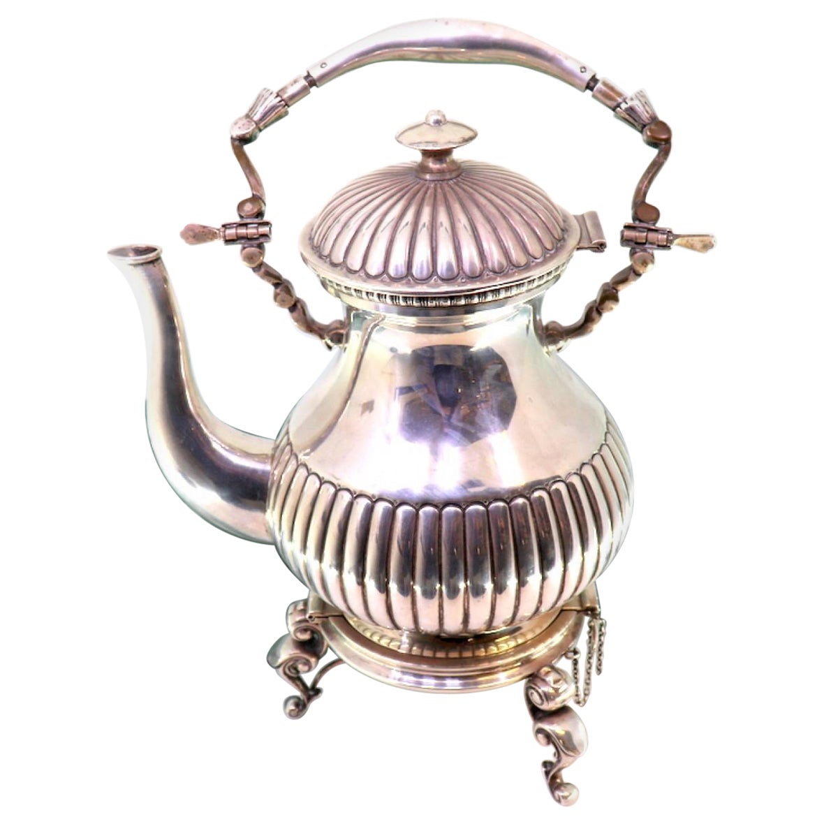 Silver kettle with embossing, trivet and heater on three tall feet