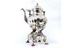 Silver kettle with fluted reliefs on lamp stand and four raised feet
