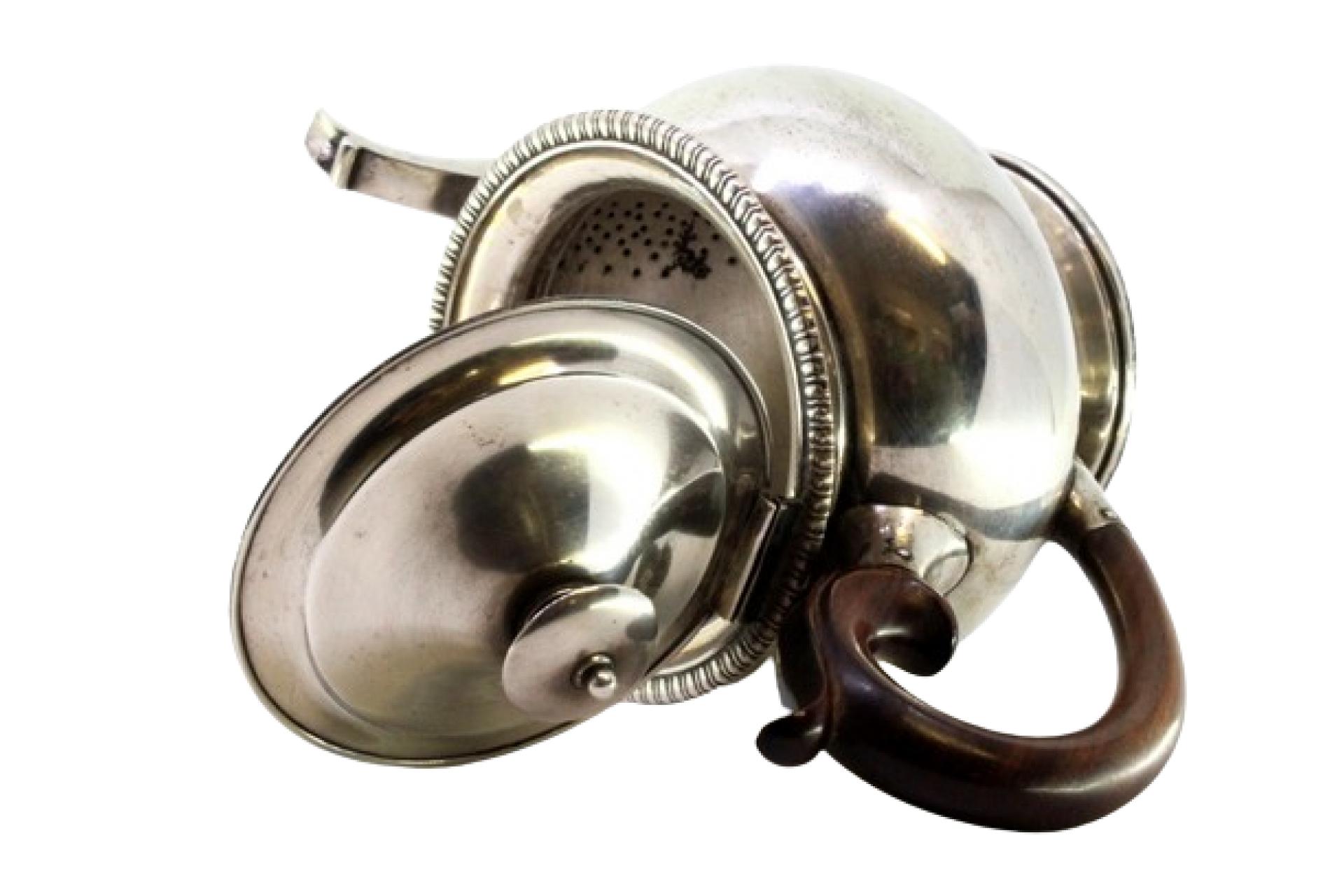 Description : Bouilloire en argent avec bord estampé, couvercle à charnière avec pommeau et poignée en bois de châtaignier. Métal : Argent. Origine : Argent. Poinçon : aigle debout. Poids : 793,82 grammes. Dimensions : 24,5 cm x 15,5 cm : 24,5cm x