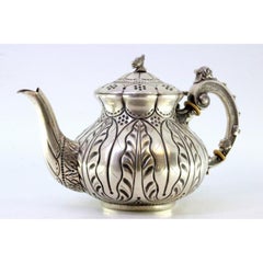 Silver kettle with relief engraving and a dragon-shaped handle on the lid