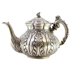 Silver kettle with relief engraving and a dragon-shaped handle on the lid