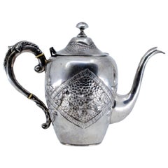 Silver kettle with reliefs and on the handle of the removable lid