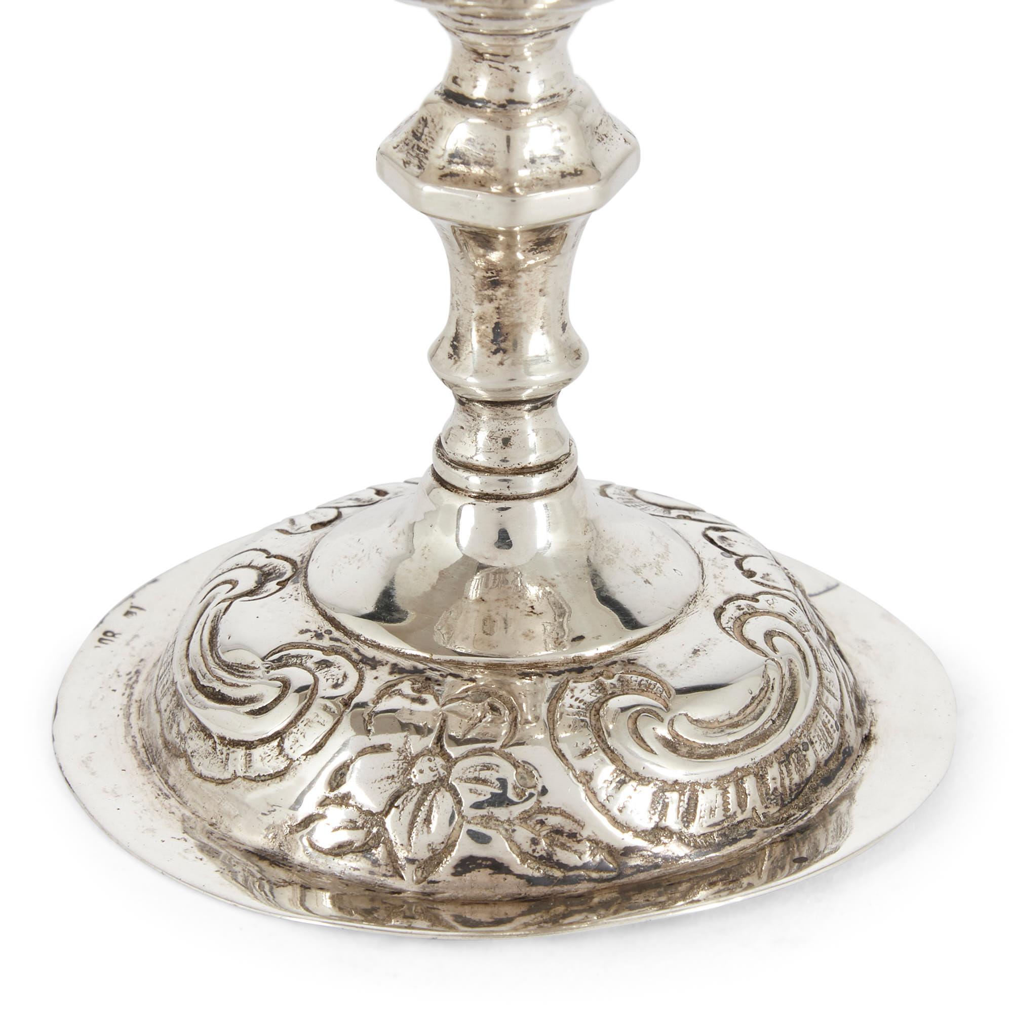 Silver Kiddush cup in 18th century style from Germany
German, late 19th century
Measures: Height 11.5cm, diameter 7cm

This fine Jewish Kiddush cup is of typical form with circular base and hexagonal bowl decorated with flowers and Hebrew