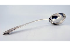 Silver ladle with relief handle and acanthus leaf monogram cartouche
