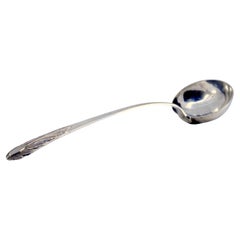 Silver ladle with relief handle and acanthus leaf monogram cartouche
