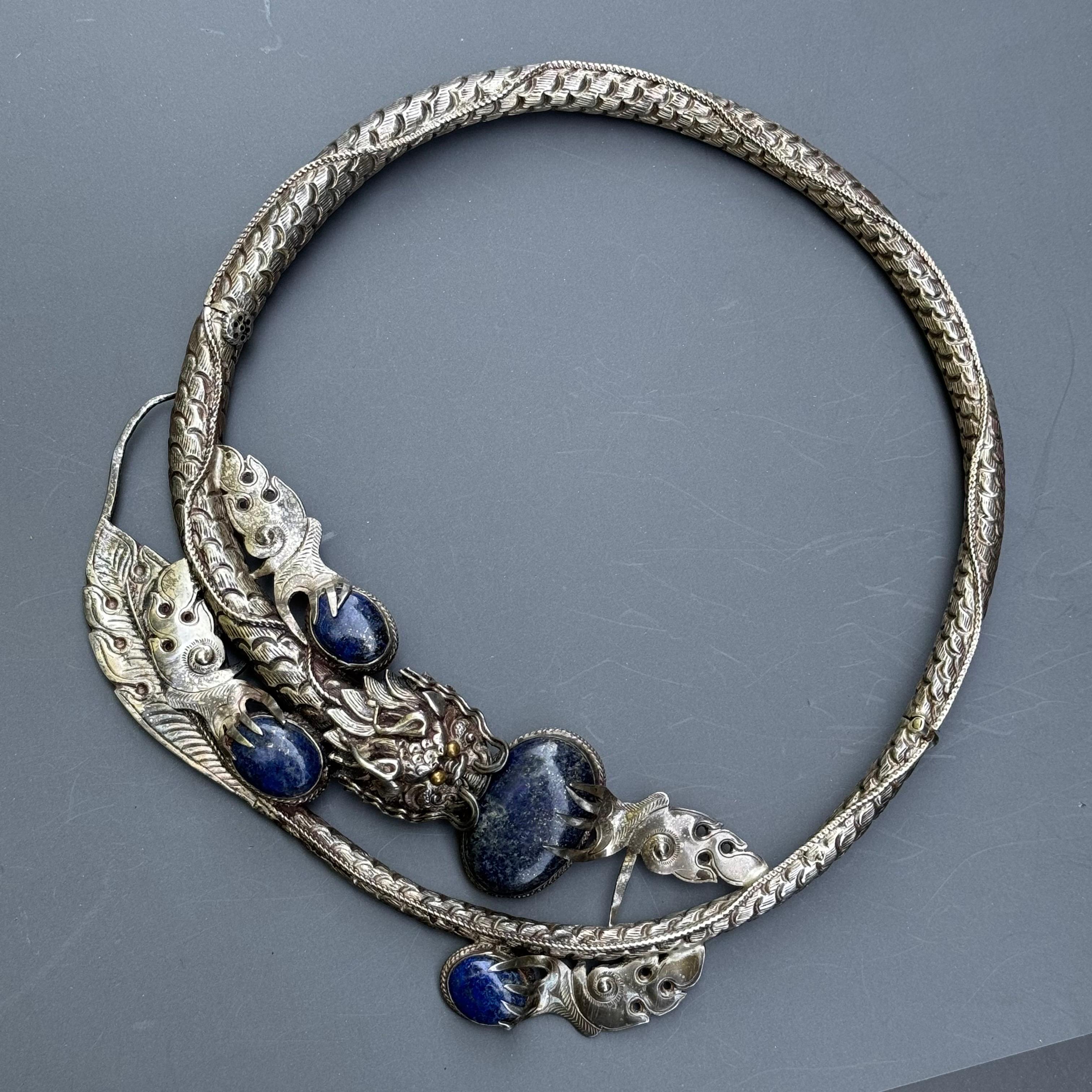 Scopri uno splendido pezzo di gioielleria cinese vintage con questa collana a pettorale in argento massiccio, realizzata con maestria da un abile argentiere. Questa collana è la testimonianza di una maestria superiore e di un design intricato, con